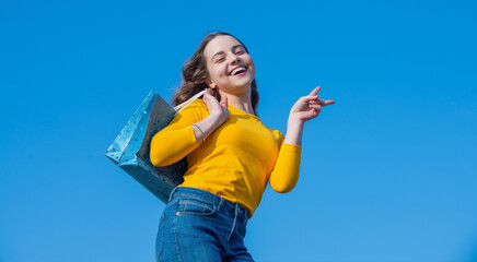 positive teen girl with shopping bag, peace