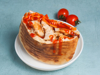 pita with chicken and vegetables drizzled with ketchup