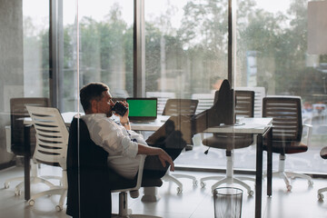 Working overtime in office, tired senior manager satisfied with his work resting in chair after work day..