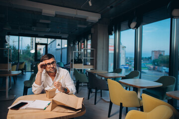 A senior manager orders street food to the office. Dinner in the office, overtime work concept..