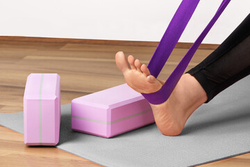Woman yoga workout with yoga blocks and yoga strap. Healthy lifestyle.