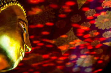 Buddha's golden face, The background is the reflection of the stained glass on the red ceiling.
