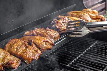 Roasted ribs. Grilled meat. Cook on fire. A ruddy crust. Fatty foods. Grilled pork. Appetizing pieces of fried meat on the grill.