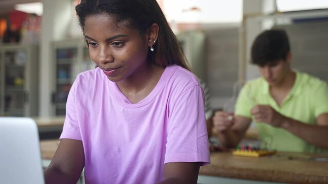 African American High School female teenage Student working with laptop in the science technology workshop