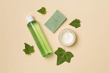 Plakat Cosmetic products with ivy extract on color background, top view