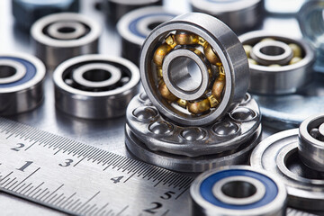 Obraz premium different bearings, vernier caliper and ruler on metal background. Part of mechanism.