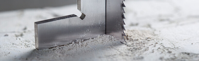 Metal saw, end mill or drill bit with diamond coating makes hole in concrete slab. Industry and construction.