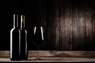 Bottle of red wine and wine glass over wooden table