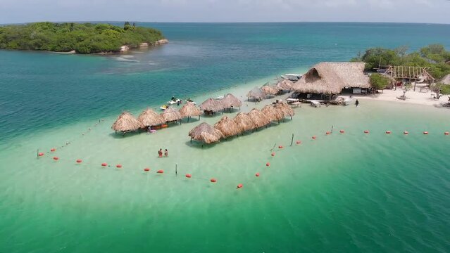 Aerial panoramic view flying over El Cholon island with bungalows and a nice tropical beach, in Baru, Islas del Rosario, Cartagena, Colombia