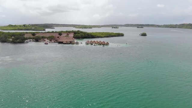 Aerial panoramic view flying over El Cholon island with bungalows and a nice tropical beach, in Baru, Islas del Rosario, Cartagena, Colombia