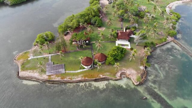 Aerial view flying over a caribbean island with bungalows surrounded by tropical trees in Baru, Cartagena, Colombia