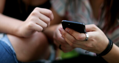 Female hands holding cellphone. Close-up finger pointing at smartphone screen
