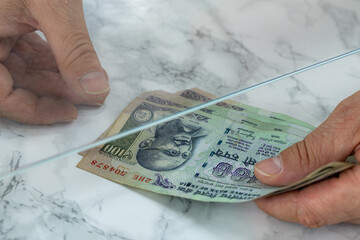 Indian money clip, 100 rupee banknotes, Passing through a bank window, Creative concept, Paying...