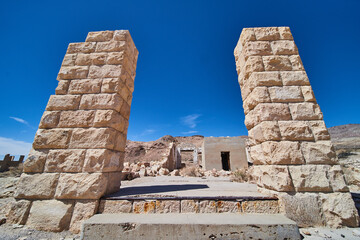 Fototapeta na wymiar Two large stone pillars and steps leading into abandoned ghost town structure