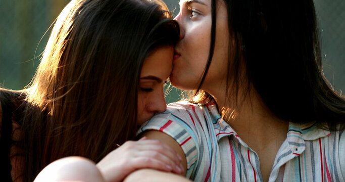 Candid lesbian girlfriends in caring affectionate moment. LGBT gay female couple relationship