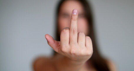 Angry young woman giving the middle finger to camera