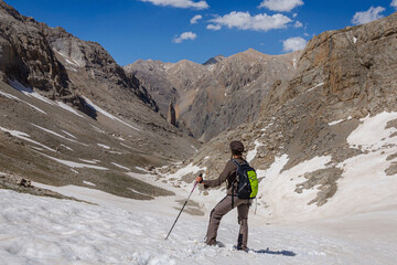 A female tourist with a backpack descends from the pass in the snow. Turkey Aladaglar