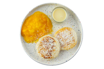 White plate with fried curd pancakes or syrniki, horizontal shot, sprinkled with coconut. Top view