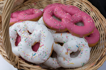 white and pink cakes lie in a wicker basket