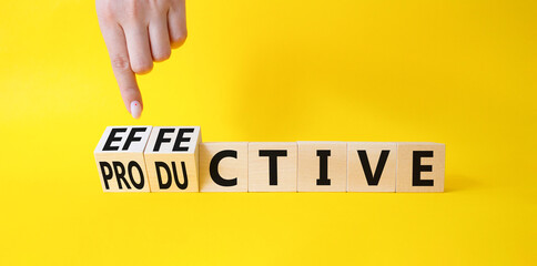 Effective and Productive symbol. Businessman Hand turns a cube and changes the word Productive to Effective. Beautiful yellow background. Business and Effective and Productive concept. Copy space
