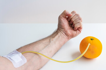 Transfusion of vitamin C from an orange to an arm. Concept on the benefits of vitamin C fruit...