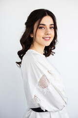 Beauty profile portrait of a pretty young woman wear white shirt, posing in a studio, isolated white background.