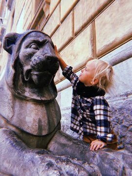 a kid and a statue of lion
