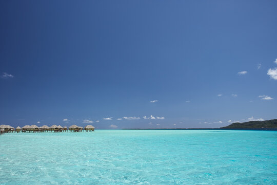 Overwater bungalow hotel rooms on tropical island and lagoon 