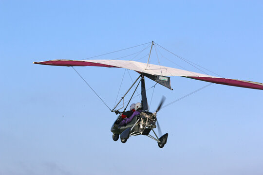 Ultralight airplane flying in a blue sky	