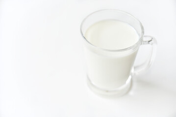 Glass transparent glass with milk on a white background.