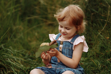 Fototapeta na wymiar Girl petting a big snail on a tree