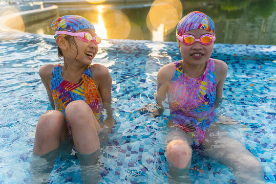 two asian kids having fun in the swimming pool
