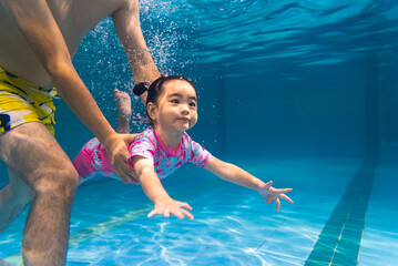little girl diving underwater