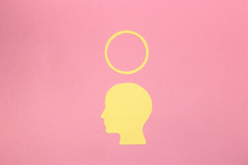 yellow paper head with halo above as copy space, creative art modern design on pink background
