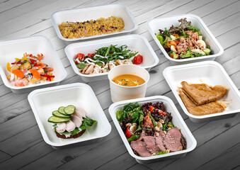 A set of healthy food dishes in ecological packaging on a wooden background. Food delivery. Takeaway.