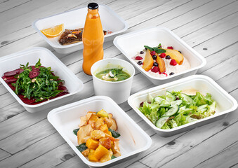 A set of healthy food dishes in ecological packaging on a wooden background. Food delivery. Takeaway.