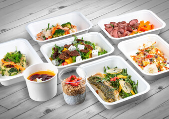 A set of healthy food dishes in ecological packaging on a wooden background. Food delivery. Takeaway.