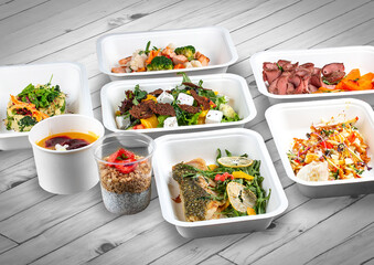 A set of healthy food dishes in ecological packaging on a wooden background. Food delivery. Takeaway.