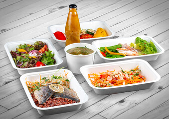 A set of healthy food dishes in ecological packaging on a wooden background. Food delivery. Takeaway.