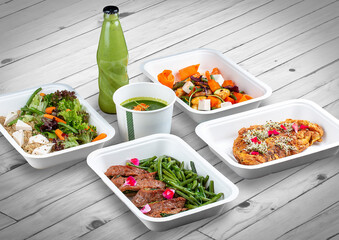 A set of healthy food dishes in ecological packaging on a wooden background. Food delivery. Takeaway.