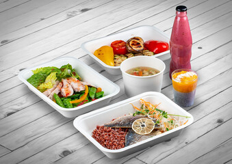 A set of healthy food dishes in ecological packaging on a wooden background. Food delivery. Takeaway.