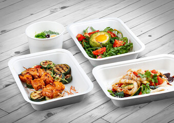 A set of healthy food dishes in ecological packaging on a wooden background. Food delivery. Takeaway.