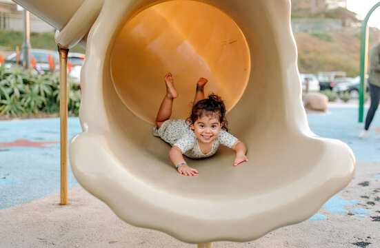Happy young girl on belly in tube slide