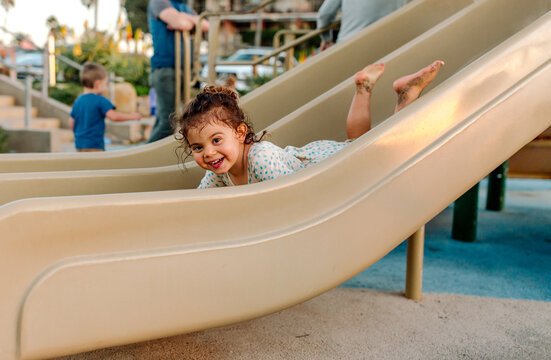 Happy young girl on belly on slide