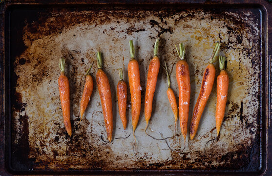 Baked carrots on a metal cooking tray.