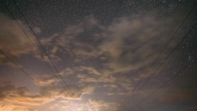 Electrical Power Lines In Starry Sky Background Time Lapse, TimeLapse, Time-Lapse. 4K Sunset Sky Transition To Dark Night Starry Sky With Glowing Stars And Meteoric Track Trail. Landscape with