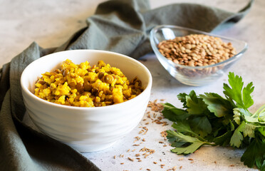 Mujadara made of lentils and rice on concrete background with gray textiles