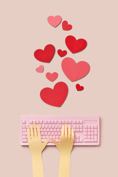 Papercraft male hands typing on keyboard with hearts around