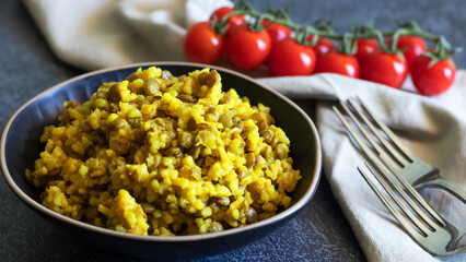 Mujadara made of lentils and rice on dark background with light textiles
