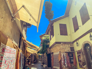 a small, narrow street lined with two-story houses with white walls. the buildings were painted and...
